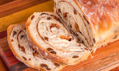 Rolled Cinnamon Raisin Bread on a Wooden Cutting Board — Bloomington, MN — Denny's 5th Avenue Bakery